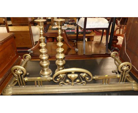 An Art Nouveau brass and floral pierced fire fender, together with a pair of brass knopped pricket sticks (3)