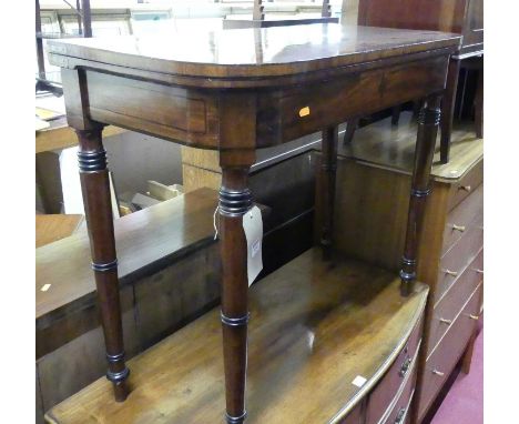 A Regency mahogany and ebony inlaid D-shaped fold-over baize lined card table, with rear gateleg action and raised on ring tu