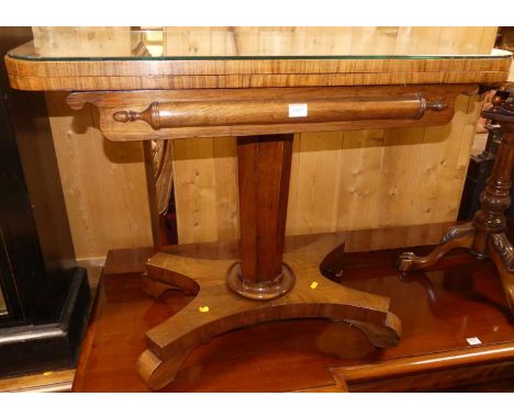 An early Victorian rosewood D-shaped fold-over baize lined card table, having a swivel action and raised on octagonal column,