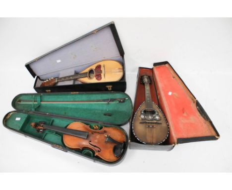 A collection of three vintage string musical instruments. Including a Luigi Ruocco mandolin, an Albertini no. 65 mandolin and
