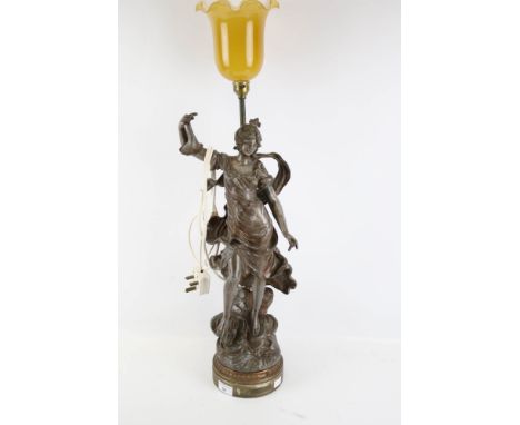 A spelter figural lamp. Titled 'Fortune', modelled as a female holding a purse, by Augustin Jean Moreau, with a yellow glass 