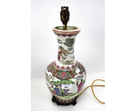 A 20th century Chinese style lamp base. Decorated in the famille rose style, featuring figures and a traditional landscape, m