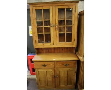 A vintage pine dresser. With glazed display top section of two doors, beneath two drawers and two door cupboard, L106cm x D45