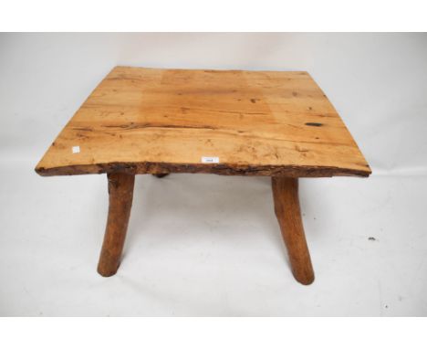 A rustic wooden coffee table. With bark sided planks on four tree trunk supports. L74cm x D69cm x H46cm