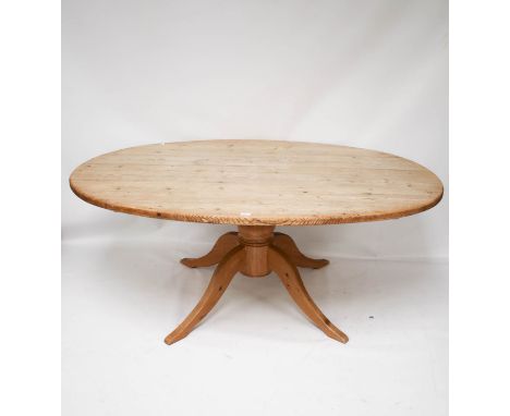 A vintage pine table. Of oval form, raised on a turned column with four swept supports, H74.5cm x W180cm x D119cm