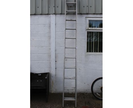 A two piece extending aluminium ladder. With eleven rugs each.