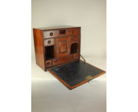 An oak stationery box with fold-down front, writing top enclosing fitted interior of small drawers and pigeon holes, 50cm
