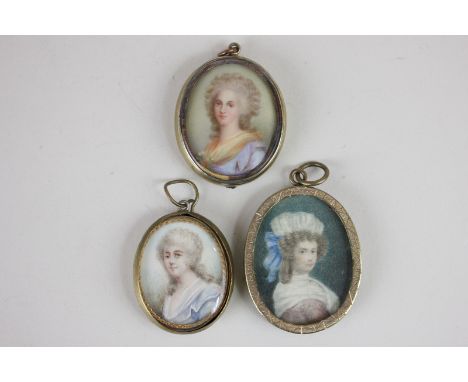 Three oval portrait miniatures of ladies in 18th century costume, to include a lady wearing a blue dress, inscribed verso Mis