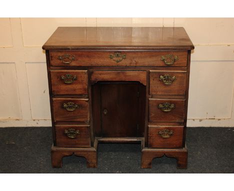 A George III mahogany knee-hole desk, with eight drawers around a cupboard door, 84cm