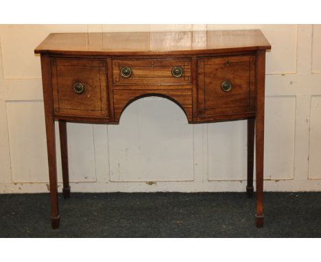 A 19th century small mahogany and ebony line inlaid bow-front sideboard with an arrangement of three drawers, on square taper