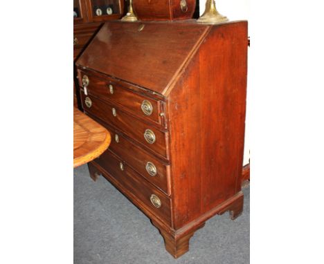 A George III mahogany bureau with fall enclosing an interior of small drawers and pigeon holes, above four graduated drawers,