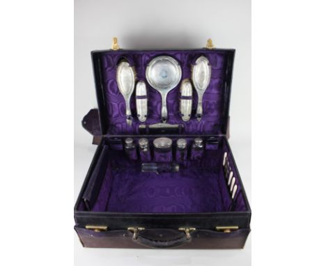 A George V silver travelling toilet set, maker J & R Griffin, Chester, 1911, the case fully fitted, with purple lining, and e