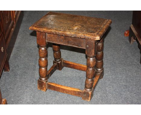An oak rectangular stool on four bobbin turned legs with low uniting stretchers
