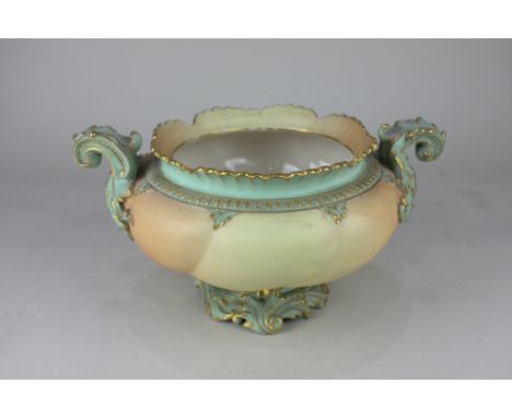 A Royal Worcester porcelain two-handled vase of squat scalloped form with scrolling foliate design on blush ground, with puce