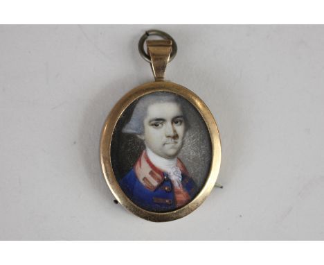An oval portrait miniature of an 18th century officer wearing a blue and red trimmed jacket, 3cm by 2.5cm
