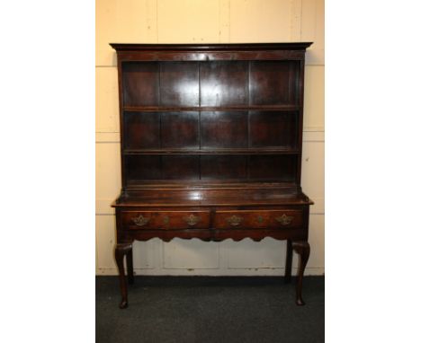 A George III oak dresser with raised two-shelf back under moulded cornice, on base with two drawers and cabriole legs, 137cm