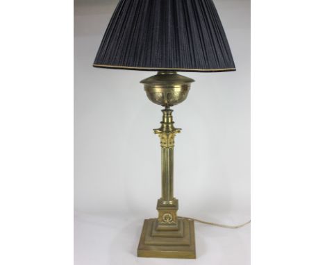 A 19th century brass column oil lamp converted into a table lamp, with black shade, 80cm high