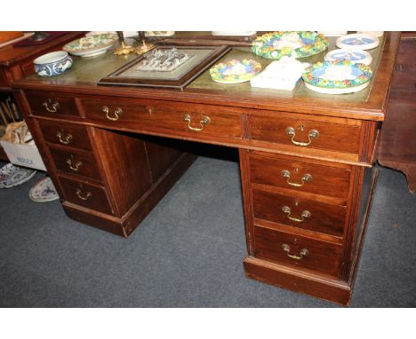 A Victorian mahogany pedestal desk with green leather inset rectangular top, and an arrangement of nine drawers, on plinth ba