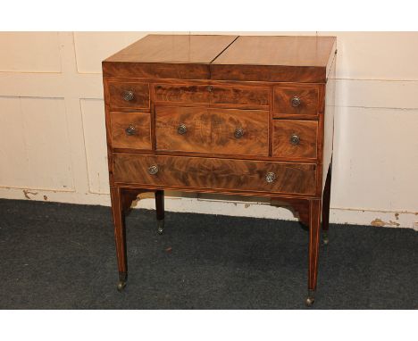 A George III mahogany dressing table with hinged divided rectangular top enclosing an easel toilet mirror and lidded wells ab