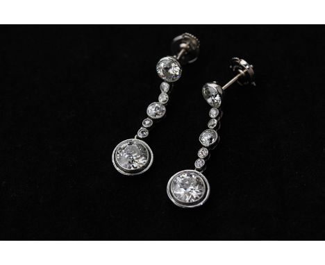 A pair of diamond drop earrings, millegrain set with an old cut diamond from a chain of six graduated smaller stones