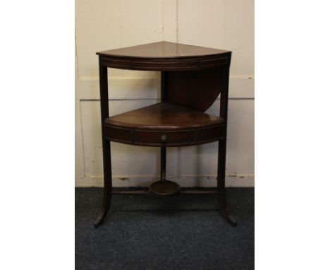 A George III mahogany corner bow-front washstand with rising splash-back top revealing aperture for washbowl and cups, centra