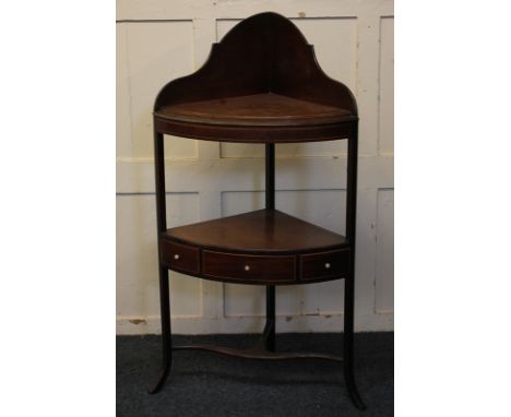 A George III mahogany corner bow-front washstand, central shelf with drawer, and later panelled top, 59cm