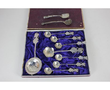 A boxed set of six white metal teaspoons with matching caddy spoon and strainer, all with figural finial, stamped 800, togeth
