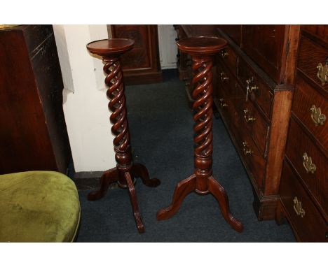 A pair of Victorian style mahogany jardiniere stands, with circular tops on open spiral column supports and tripod legs, 96cm