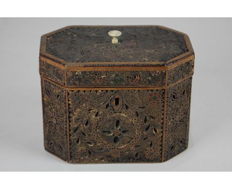 An 18th century 'straw work' tea caddy, the octagonal sides and hinged top worked with panels of straw in a leaf and flower p