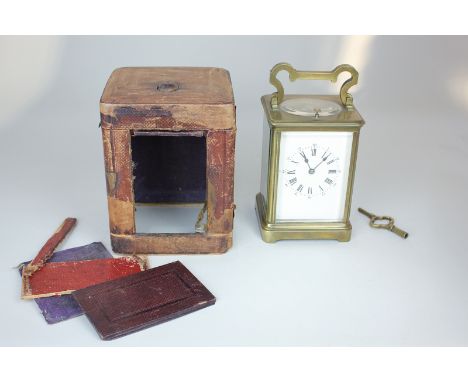 A brass and bevelled glass cased carriage clock, the repeater movement striking on a gong, 18cm high, with leather travelling