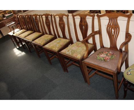 A set of eight Chippendale style dining chairs including two carvers, with non-matching tapestry upholstered seats, pierced v