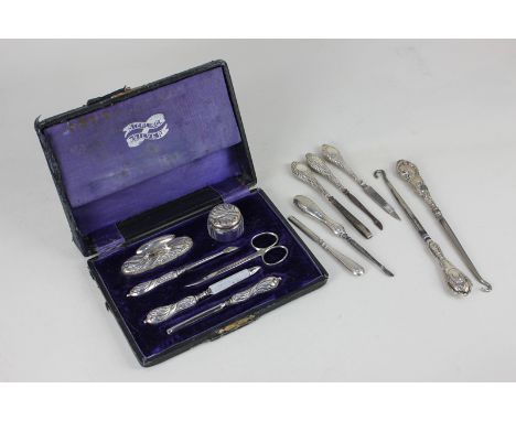 A George V cased silver manicure set, fitted case, including nail buffer, silver topped glass jar, scissors and tools, Birmin
