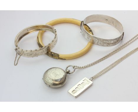 A silver sovereign case on chain, a silver ingot on chain, two silver bangles, and a bone bangle