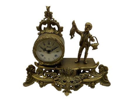 20th century cast brass mantle clock with a circular drum movement accompanied by a figure of a young boy with a catch of fis