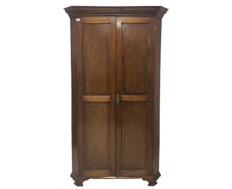 Georgian design mahogany corner wardrobe, the projecting cornice over two panelled doors, opening to reveal interior fitted f