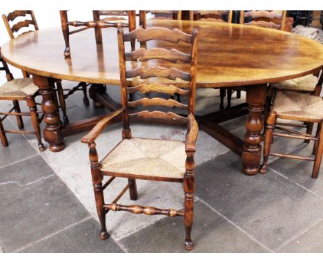 An aged oak refectory table and ten rush seat ladder back chairs by Titchmarsh & Goodwin. Table dimensions: L245cm D153cm H76