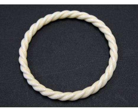 A twist ivory bangle circa 1900, diam. 7.5cm