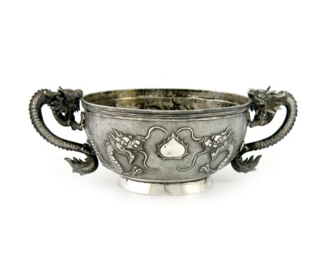 A Chinese silver two-handled bowl, maker's mark of KMS, with dragon scroll handles, the body embossed with two dragons on a m