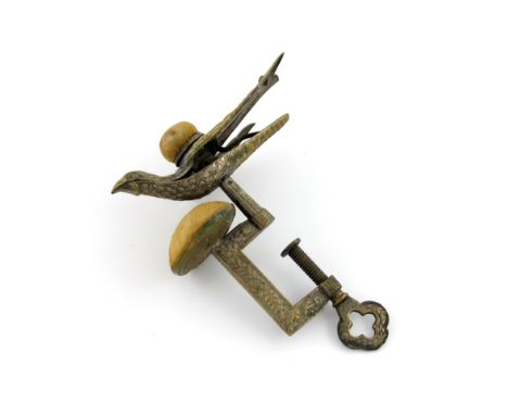 A 'sewing bird' sewing clamp, the clamp with foliate decoration, and with a cushion, the sprung-hinged bird with textured fea