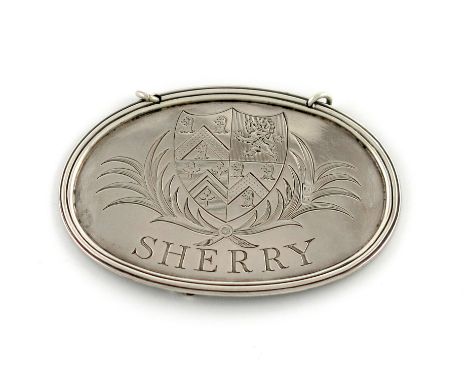 A large George III silver wine label, maker's mark worn, London 1791, oval form, engraved with an armorial within foliate man