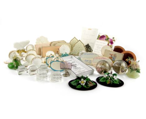 A large collection of ceramic and glass menu card holders, comprising: a Copeland shell, on a blue rocky base, an oval pair w