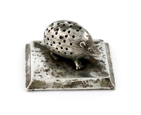 An Edwardian novelty silver hedgehog pin cushion, maker's mark worn, Birmingham 1908, mounted on a tapering rectangular base,
