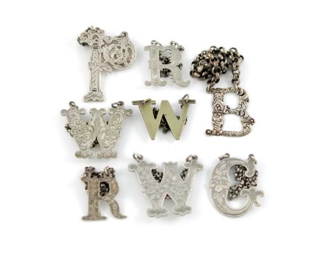 A collection of eight Victorian silver and electroplated 'cut-out letter' wine labels, comprising: Scottish and English silve