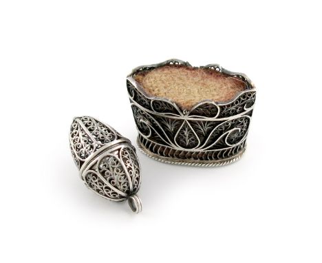 A George III silver filigree pin cushion, circa 1800, tapering oval basket form, length 3cm, plus a filigree egg, hinged cove