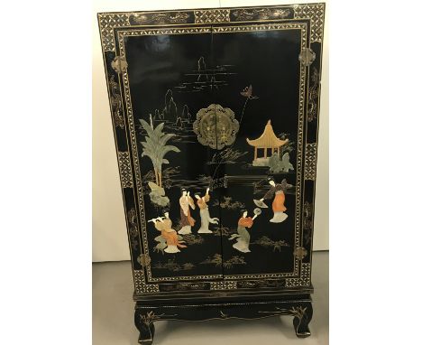 A decorative Chinese black lacquer 2 door cabinet with natural shell applied decoration in relief. Mother of pearl inlay deta