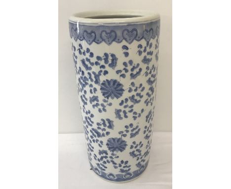 A blue and white Chinese ceramic umbrella stand with hand painted floral decoration.  Approx. 46cm tall x 21.5cm diameter.