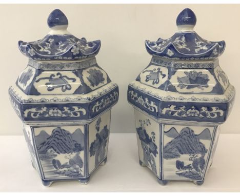 A pair of Chinese ceramic blue and white hexagonal shaped temple jars. Decorated with alternate landscape and floral panel sc
