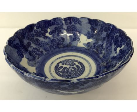 A blue and white ceramic bowl with blossoming tree decoration.   Approx 25cm diameter.