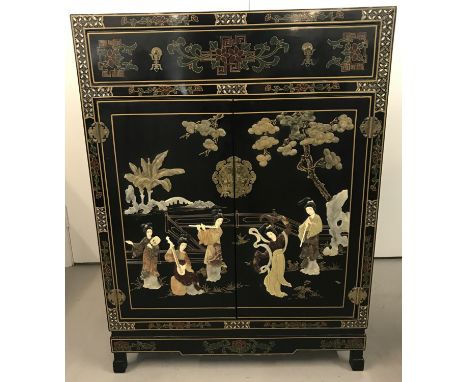 A Chinese black lacquer 2 door single drawer cabinet with natural stone applied decoration in relief Mother of pearl inlay de