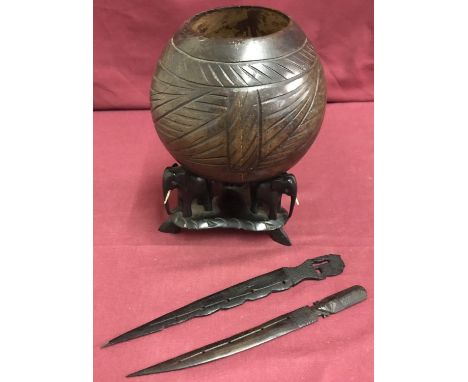 3 wooden carved ethnic items. Comprising: 2 African letter openers with hand carved handles together with a carved coconut sh